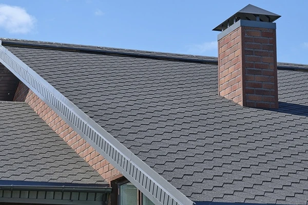 На скатах — гибкая черепица, на дымоходах — фасадная плитка.