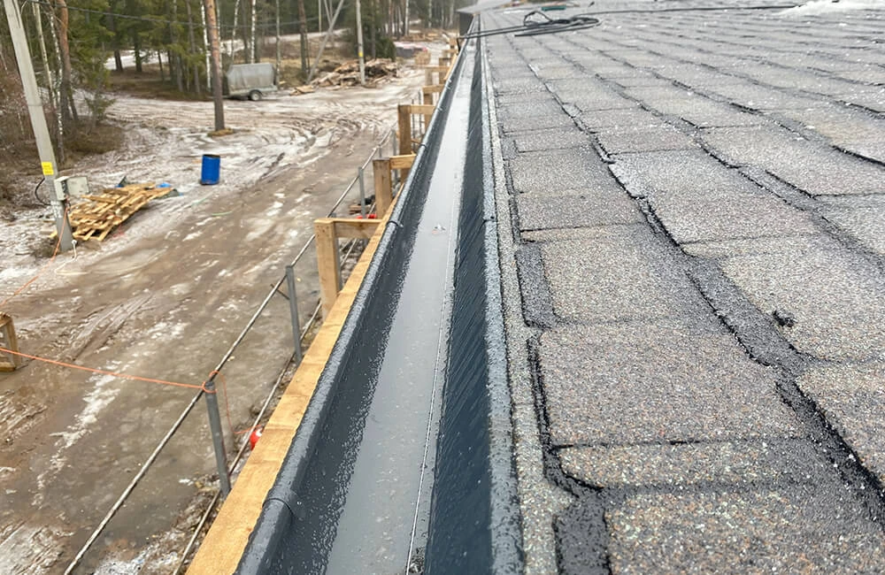 Подкладочный ковер приклеен поверх карнизной планки с отступом на 10 мм от перегиба. Гибкая черепица также смонтирована с отступом от перегиба карнизной планки (во время съемки на крыше была наледь)