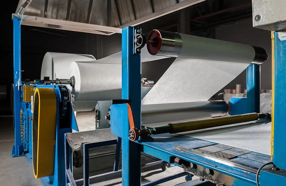 Стеклохолст склеивают, прежде чем он станет основой для гибкой черепицы.