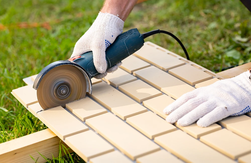 Обрежьте панель по разметке с помощью болгарки. Обрезок не выбрасывайте — его можно использовать в конце ряда.