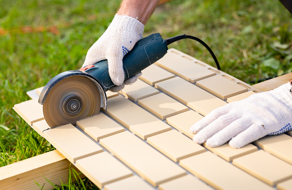 Обрежьте панель по разметке с помощью болгарки. Обрезок не выбрасывайте — его можно использовать в конце ряда.