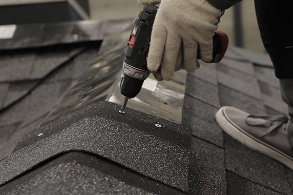 Установите коньковые аэраторы для подкровельной вентиляции и саморезами закрепите коньково-карнизную черепицу.