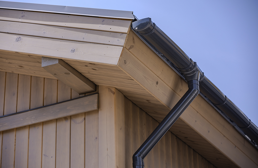 Дом МОНЕ 60: свесы крыши полностью оформлены деревянной доской, несущие балки — полуоткрытые, между рейками, которыми подшиты свесы, предусмотрены зазоры для вентиляции подкровельного пространства.